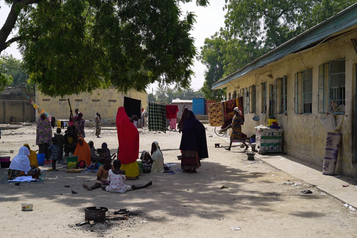 A group of women pass the afternoon in NYSC IDP Camp, which houses around 6,000 Nigerians. Some are making handicrafts, like the traditional Nigerian caps, in order to make some money to feed their c