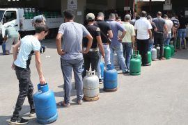 People queue to refill domestic gas cylinders at a petrol station in the Ouzai area of the capital Beirut [Nabil Mounzer/EPA-EFE]