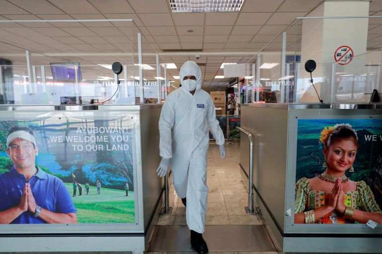 An officer wearing protective gear walks inside an airport in Sri Lanka