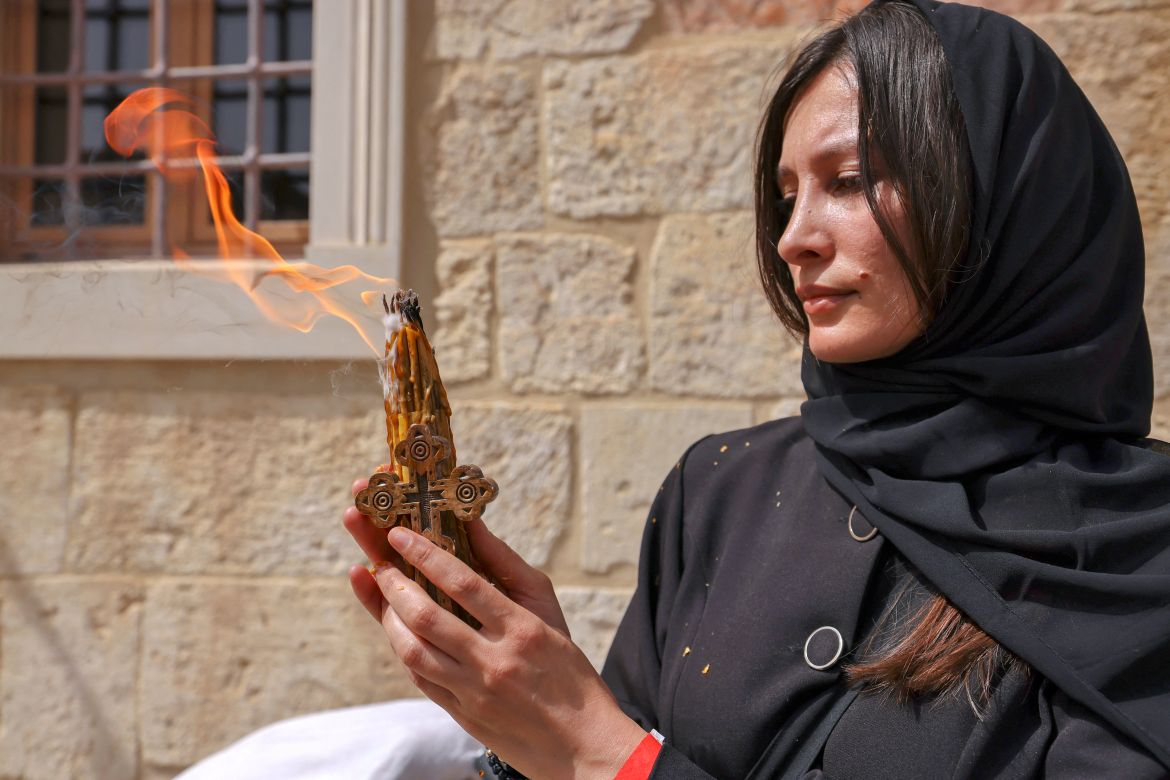A worshipper shows her lit candles