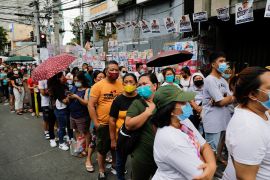 People queue outside a polling precinct to cast their ballots, during the national elections in Tondo, Metro Manila, Philippines