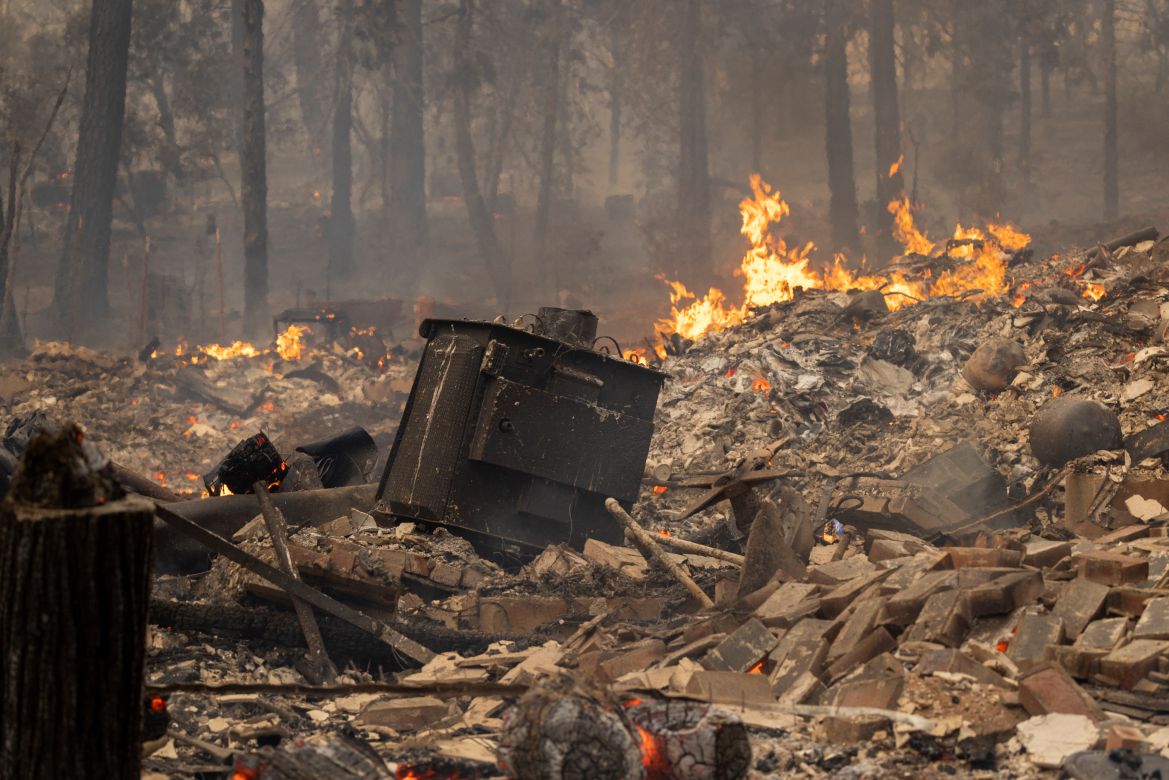 The ruins of a home destroyed in the Oak Fire smolder near Midpines