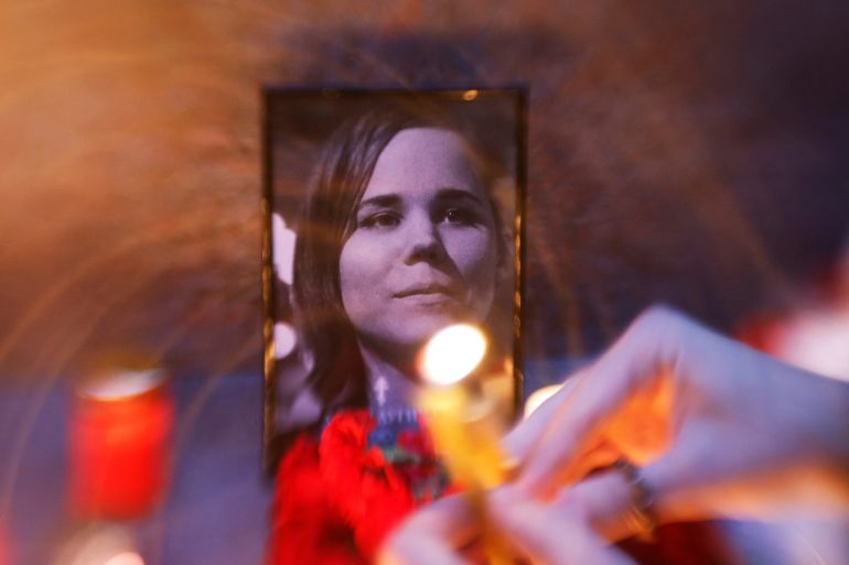 Flowers and candles are placed next to a portrait of media commentator Darya Dugina, who was killed in a car bomb attack, in Moscow.