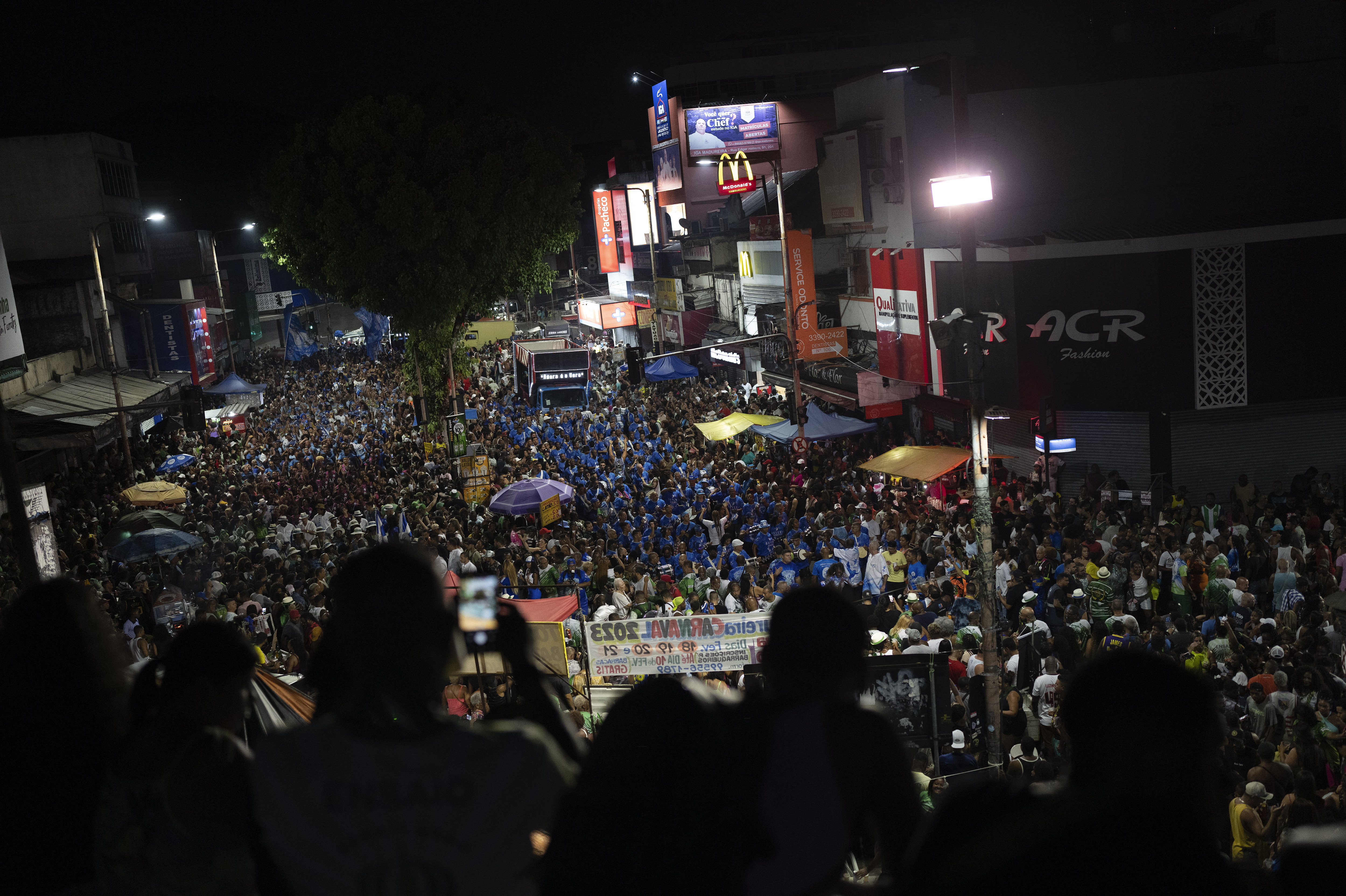 People watch from a bridge the rehearsal of the Imperio Serrano and Beija Flor samba schools