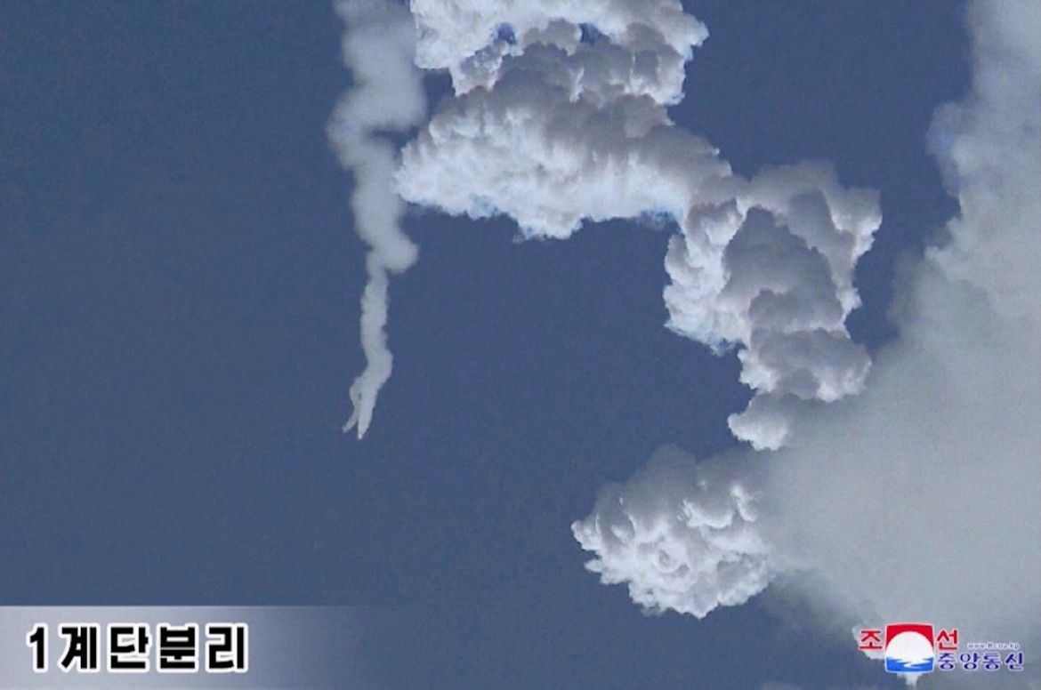 A bulbous smoke trail against a blue sky from the launch.