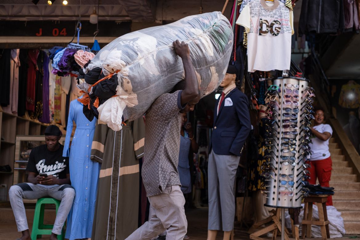 A man carries a load of second-hand clothes at a market in Kampala.
