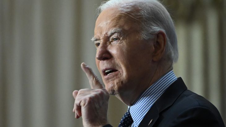 a man in a suit raises a finger