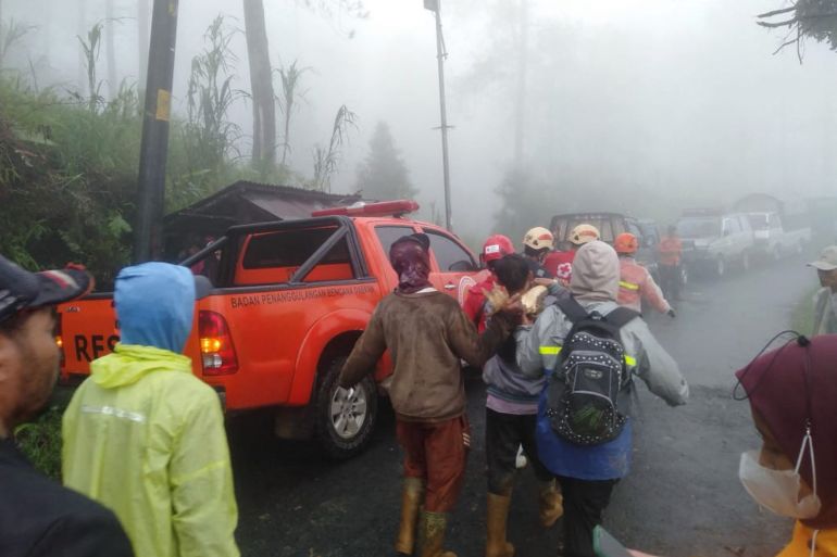 In this handout picture taken and released on January 21, 2025, by the Indonesias Disaster Mitigation Agency shows, rescueers and villagers evacuate victims of a landslide at Kasimpar Village in Pekalongan, Central Java. At least 16 people have been killed and three more are missing after a landslide triggered by heavy rain in Indonesias Central Java province, disaster officials said