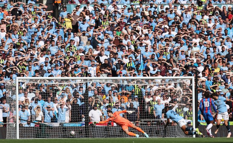 Crystal Palace's English midfielder #10 Eberechi Eze (R) watches his shot into the net as he scores the opening goal during the English FA Cup final football match between Crystal Palace and Manchester City at Wembley stadium in London, on May 17, 2025. (Photo by Adrian Dennis / AFP) / NOT FOR MARKETING OR ADVERTISING USE / RESTRICTED TO EDITORIAL USE