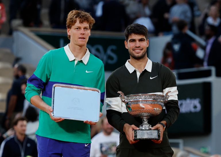 Spain's Carlos Alcaraz poses with the trophy after winning the men's singles final alongside runner up Italy's Jannik Sinner