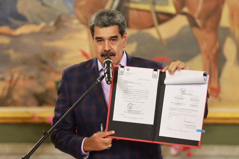 Venezuela's President Nicolas Maduro holds a folder with a national defense framework approved by Venezuela's National Assembly