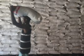 A man carries a bag of rice over his head