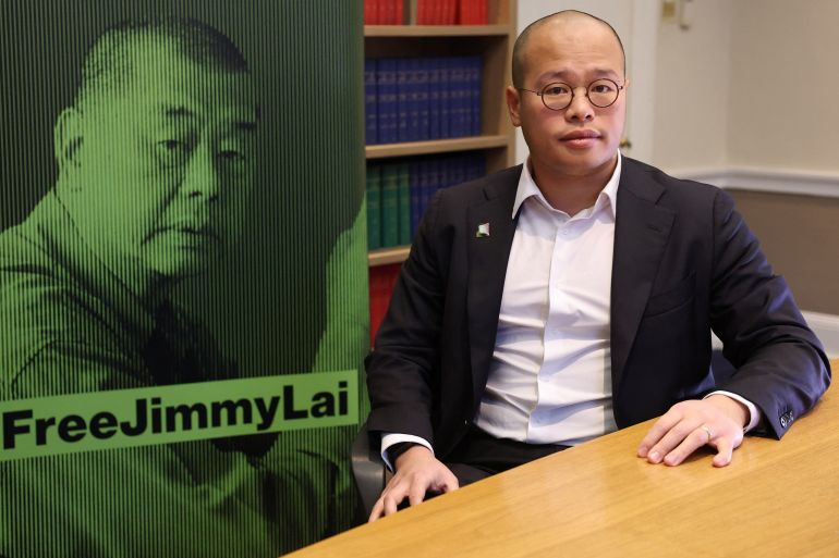 Sebastien Lai, son of jailed media tycoon Jimmy Lai, poses for a portrait next to a campaign poster featuring imagery of his father, during an interview with Reuters following his father being found guilty under Hong Kong’s national security law of conspiracy to collude with foreign forces and to publish seditious material, in London, Britain, December 15, 2025. REUTERS/Toby Melville