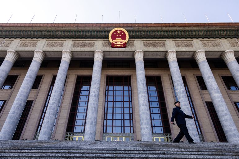 A man walks down the stairs at the entrance of the Great Hall of the People ahead of the annual meeting of the National People's Congress, in Beijing