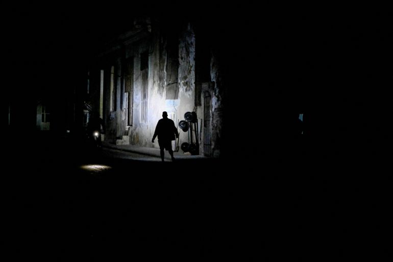A man walks on a street as Cuba's national electric grid collapsed for the second time in a week amid the US-imposed oil blockade, according to officials, as the communist government struggles to keep the lights on for about 10 million people with decrepit infrastructure, in Havana, Cuba on March 21, 2026. [Norlys Perez/Reuters]